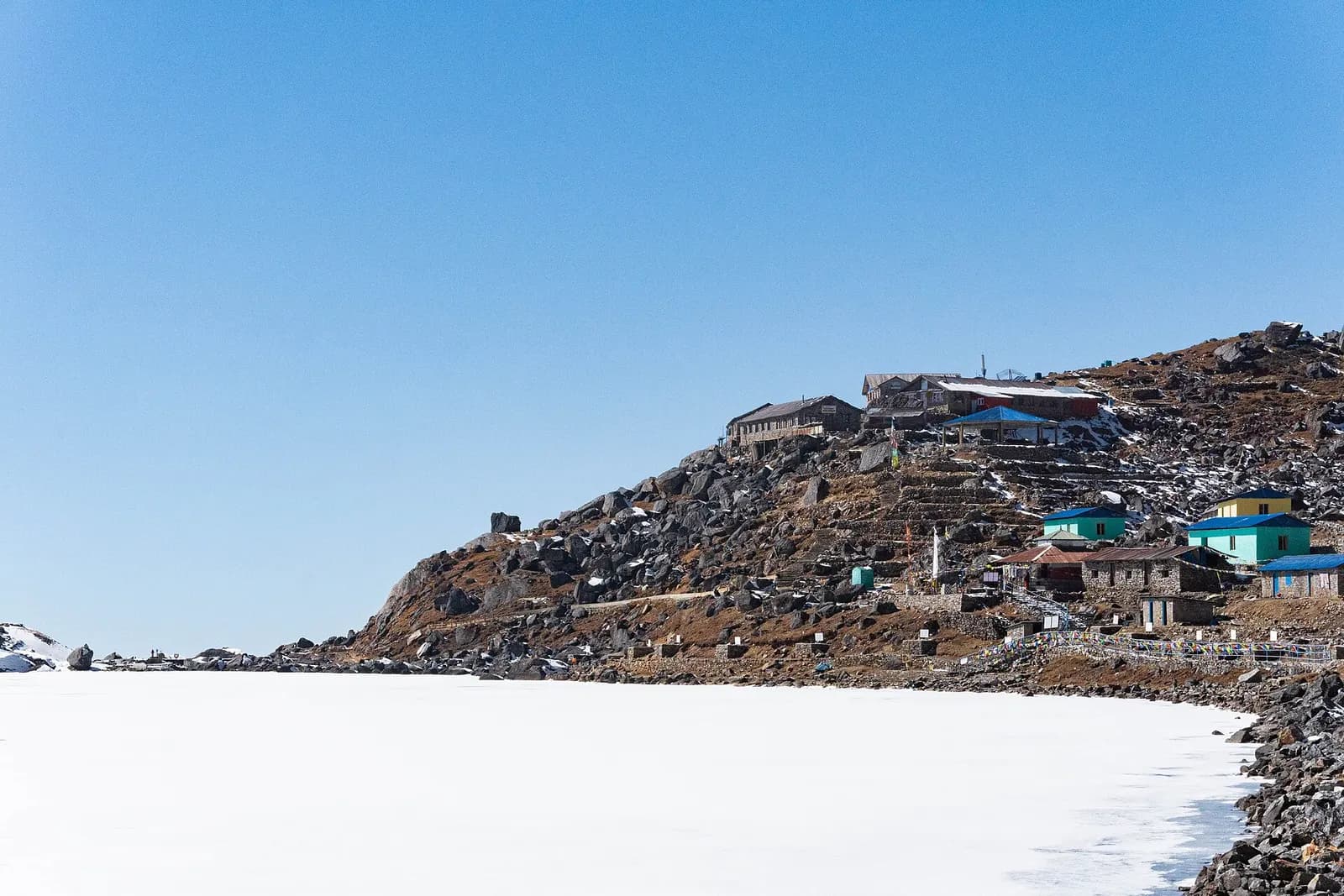 Frozen Gosainkunda Lake below a trekking lodge in winter